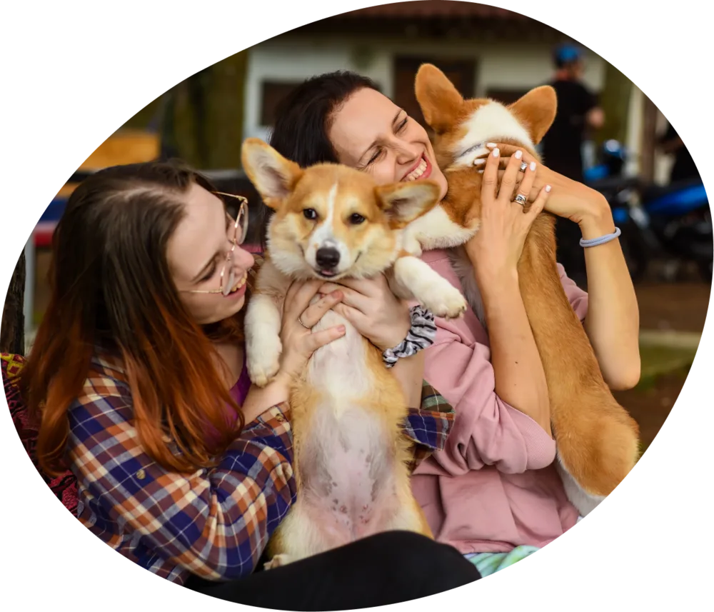 Dos personas abrazan a sus perros antes de un viaje